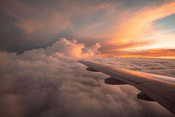 Vista desde avión al atardecer sobre las nubes